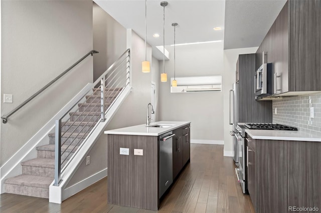 kitchen featuring tasteful backsplash, modern cabinets, stainless steel appliances, light countertops, and a sink