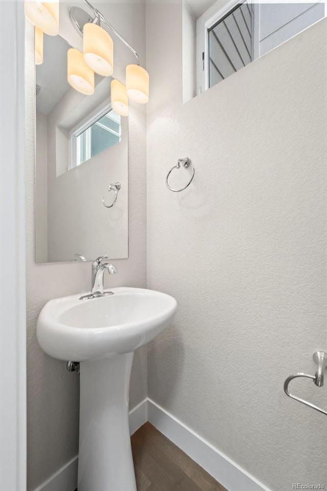 bathroom featuring a sink, baseboards, and wood finished floors