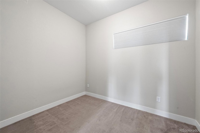 carpeted empty room featuring baseboards