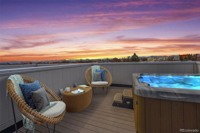 deck at dusk with a hot tub