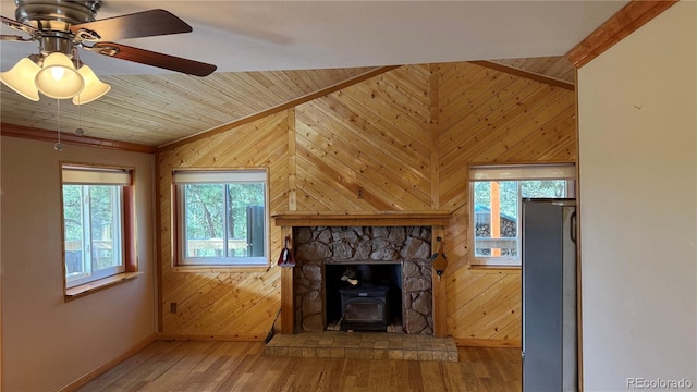 unfurnished living room with wood-type flooring, lofted ceiling, ceiling fan, and wooden walls