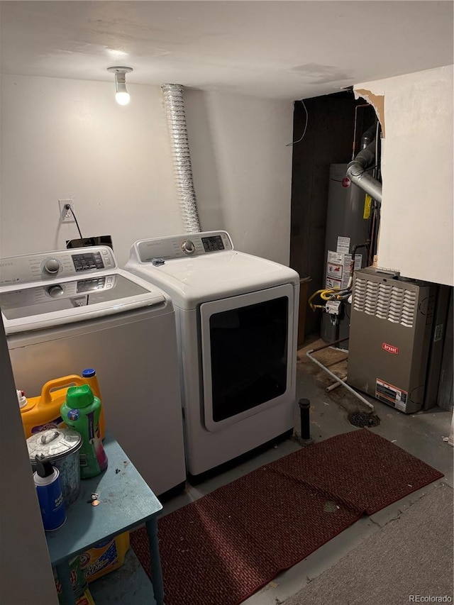 washroom with laundry area, water heater, and independent washer and dryer