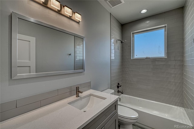 full bathroom with toilet, vanity, and tiled shower / bath