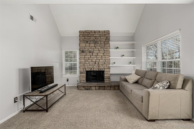 living room featuring light carpet, a fireplace, visible vents, and plenty of natural light