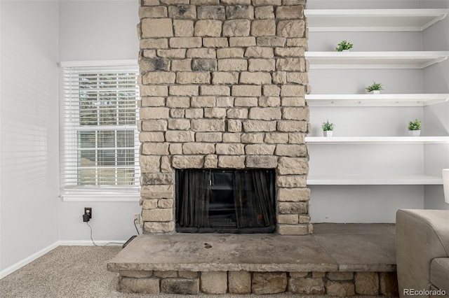 interior details with carpet floors, a stone fireplace, and baseboards