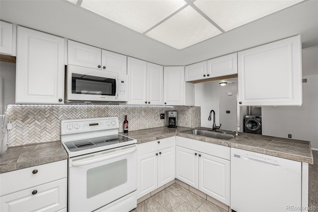 kitchen featuring white appliances, white cabinetry, a sink, and washer / dryer