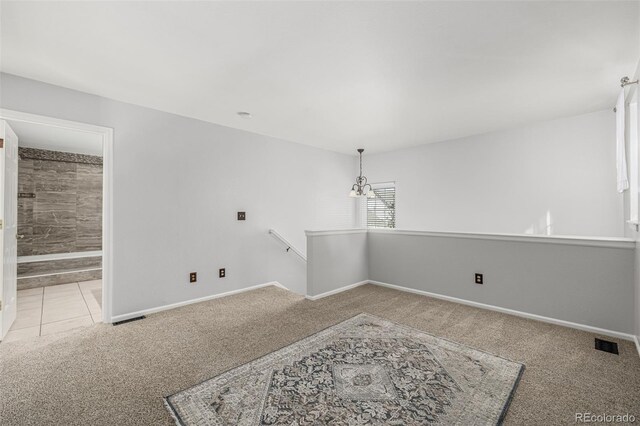 carpeted empty room with visible vents and baseboards