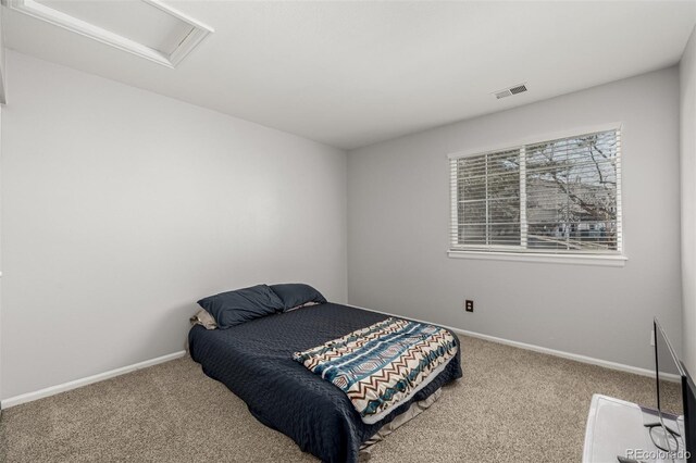 bedroom with baseboards, carpet, visible vents, and attic access