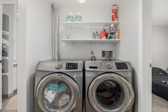 laundry room with laundry area, light tile patterned flooring, and washing machine and clothes dryer