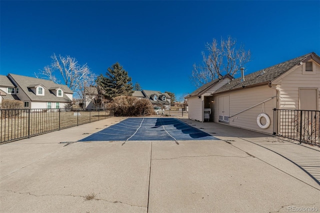 view of swimming pool featuring a residential view, fence, and a patio