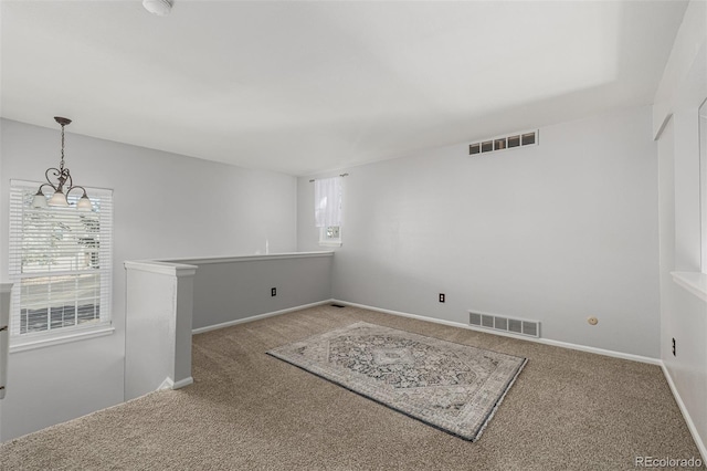 carpeted spare room featuring baseboards and visible vents