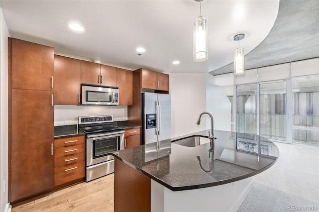 kitchen featuring appliances with stainless steel finishes, a sink, brown cabinetry, decorative light fixtures, and recessed lighting