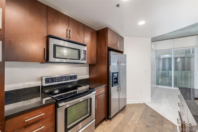 kitchen with stainless steel appliances, light wood-type flooring, dark stone counters, recessed lighting, and baseboards