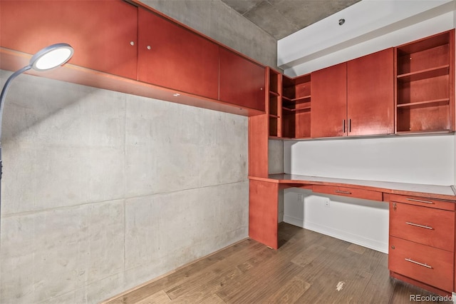 unfurnished office with built in study area and dark wood-style flooring