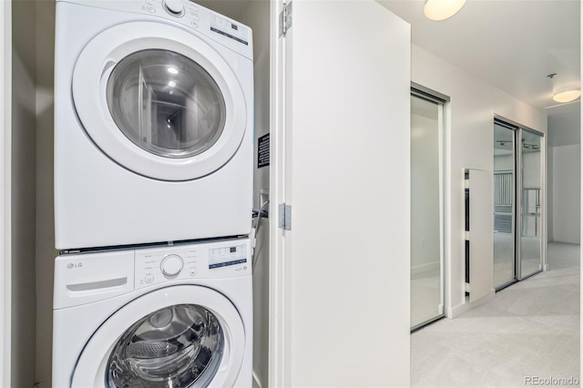 washroom featuring stacked washer / dryer and light carpet