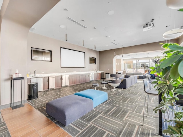 cinema room with arched walkways and a sink