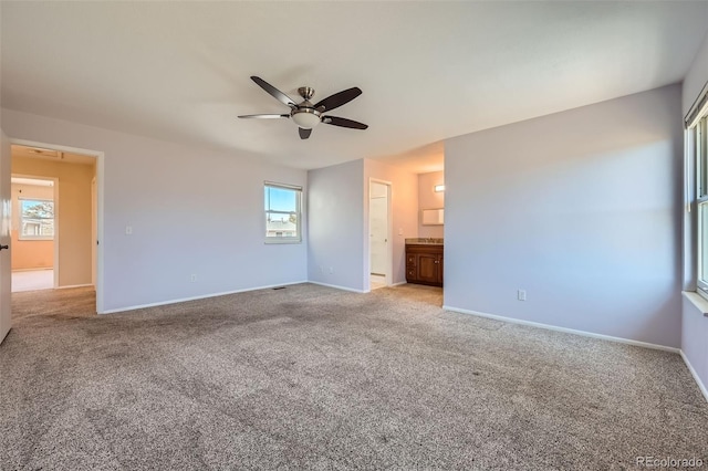 unfurnished bedroom with ensuite bath, baseboards, carpet floors, and ceiling fan