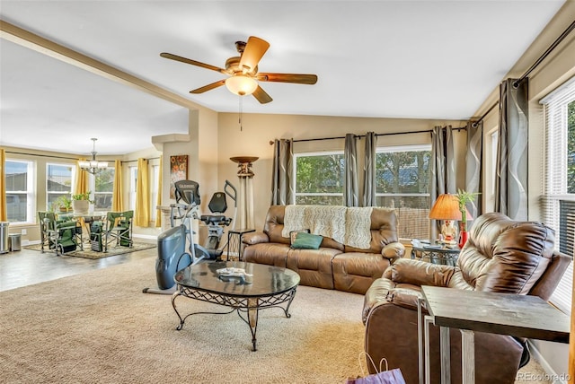 living room featuring lofted ceiling, a healthy amount of sunlight, and ceiling fan with notable chandelier