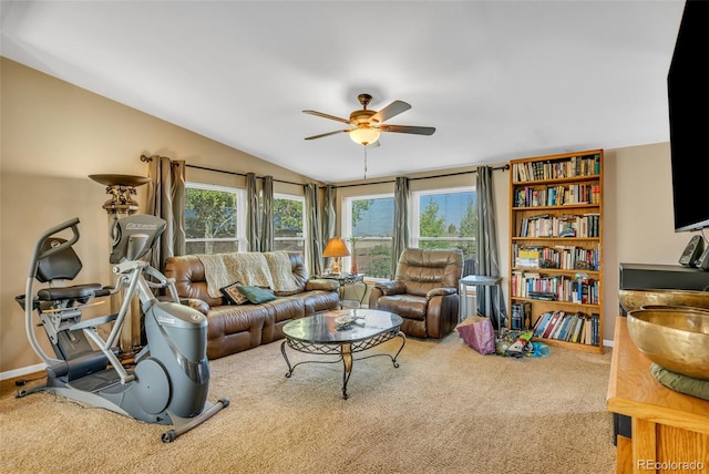 living room featuring vaulted ceiling, carpet flooring, ceiling fan, and a healthy amount of sunlight