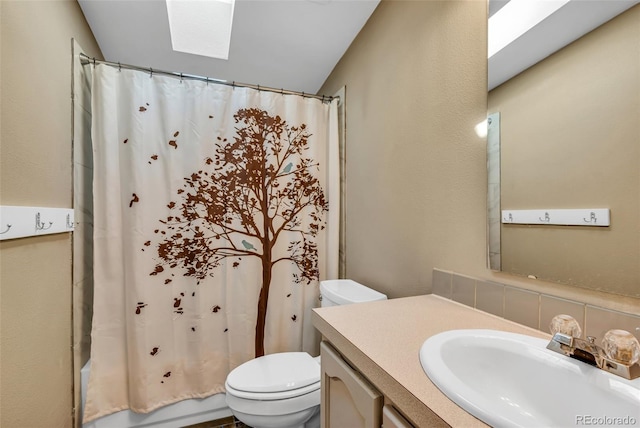 bathroom with vanity, toilet, and a skylight