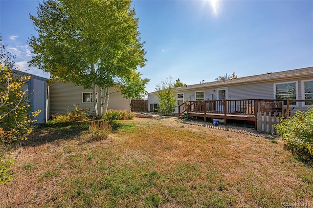 view of yard with a wooden deck and a storage unit