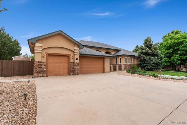 3806 S Dawson St, Aurora, CO 80014 - view of front of home with a garage, stucco siding, concrete driveway, and stone siding