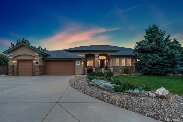3806 S Dawson St, Aurora, CO 80014 - view of front of home featuring an attached garage, stucco siding, a front lawn, driveway, and stone siding