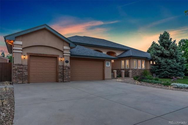3806 S Dawson St, Aurora, CO 80014 - view of front of property featuring a garage, stone siding, stucco siding, driveway, and a shingled roof