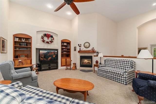 3806 S Dawson St, Aurora, CO 80014 - living room with a fireplace with flush hearth, built in shelves, ceiling fan, carpet floors, and arched walkways