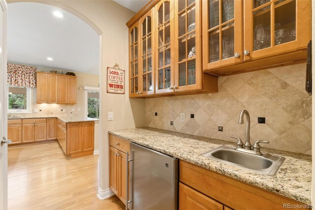 3806 S Dawson St, Aurora, CO 80014 - kitchen with a sink, refrigerator, arched walkways, backsplash, and light wood-style flooring