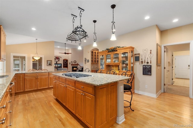 3806 S Dawson St, Aurora, CO 80014 - kitchen with a kitchen bar, stainless steel gas cooktop, light wood-style flooring, light stone countertops, and recessed lighting