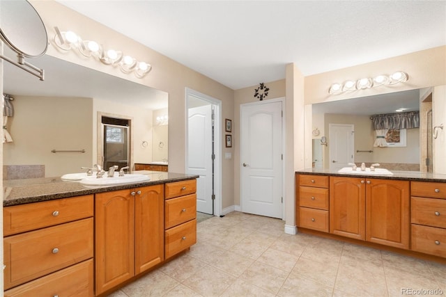 3806 S Dawson St, Aurora, CO 80014 - full bath featuring two vanities, a stall shower, tile patterned flooring, and baseboards