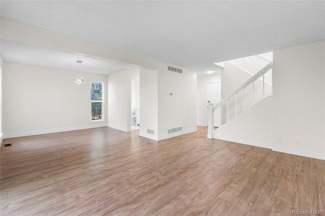1519 S Sable Blvd Unit C, Aurora, CO 80012 - unfurnished living room featuring light wood-style floors, stairway, and baseboards