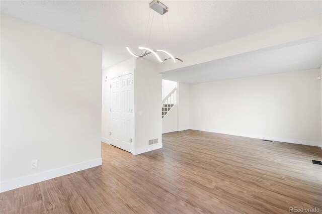 1519 S Sable Blvd Unit C, Aurora, CO 80012 - unfurnished room featuring a chandelier, wood finished floors, baseboards, and stairway