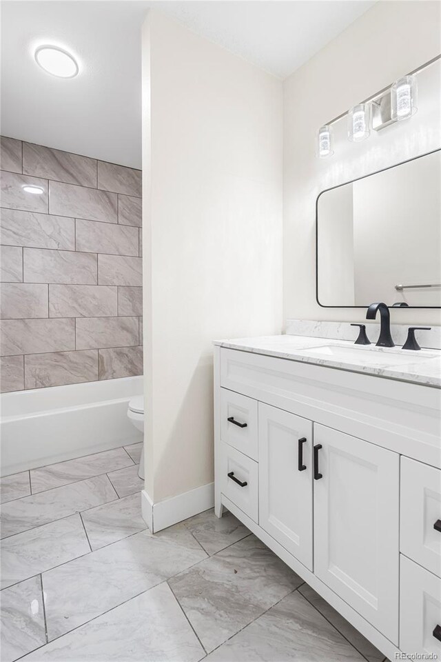 1519 S Sable Blvd Unit C, Aurora, CO 80012 - bathroom featuring marble look tile flooring, baseboards, vanity, toilet, and shower / bath combination