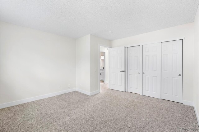 1519 S Sable Blvd Unit C, Aurora, CO 80012 - unfurnished bedroom with carpet flooring, a textured ceiling, baseboards, and two closets