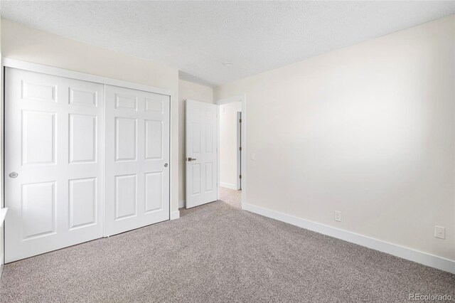 1519 S Sable Blvd Unit C, Aurora, CO 80012 - unfurnished bedroom featuring carpet, baseboards, a closet, and a textured ceiling