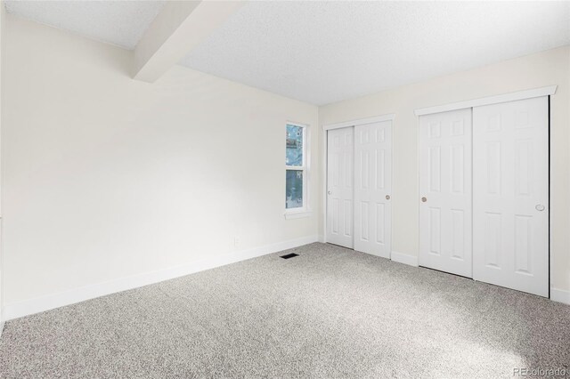 1519 S Sable Blvd Unit C, Aurora, CO 80012 - unfurnished bedroom with multiple closets, carpet flooring, baseboards, and a textured ceiling