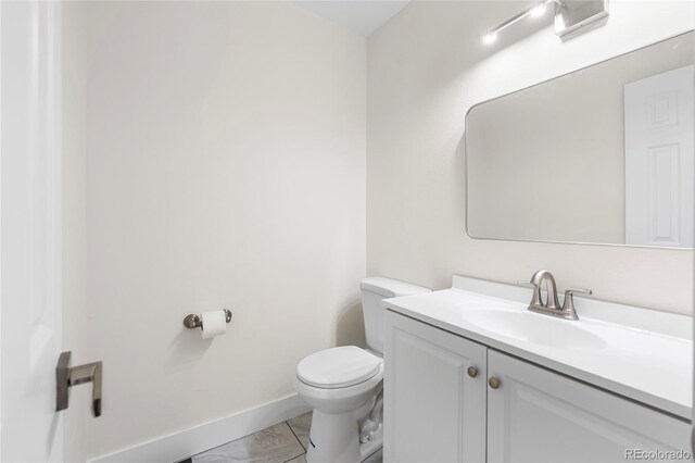 1519 S Sable Blvd Unit C, Aurora, CO 80012 - half bathroom featuring toilet, vanity, marble look tiles, and baseboards