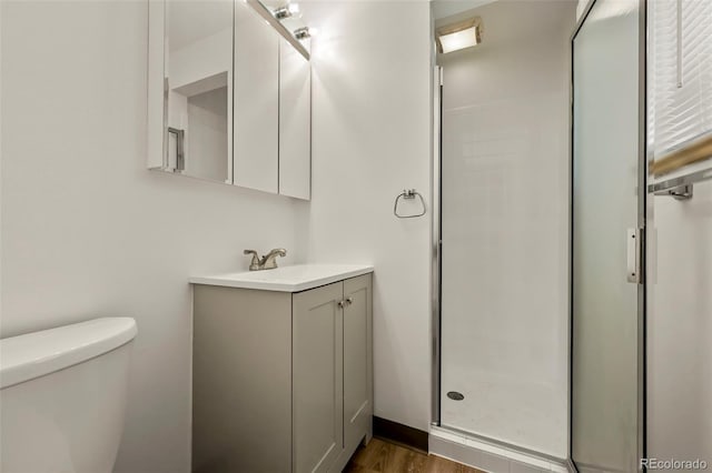 6432 Zephyr St, Arvada, CO 80004 - full bathroom featuring vanity, a stall shower, toilet, and wood finished floors