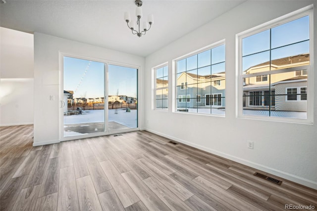 unfurnished room featuring hardwood / wood-style flooring and a notable chandelier