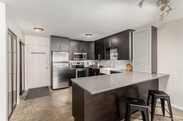 1121 Albion St Unit 809, Denver, CO 80220 - kitchen featuring stainless steel appliances, a sink, a peninsula, backsplash, and light countertops