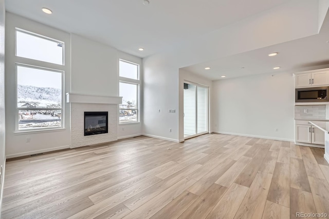 unfurnished living room featuring a mountain view and light hardwood / wood-style flooring