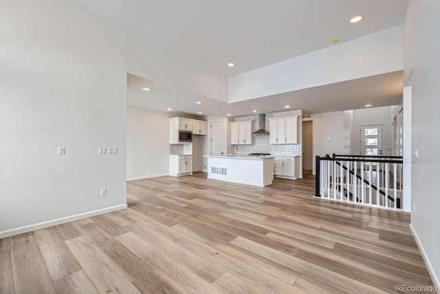 unfurnished living room featuring light hardwood / wood-style floors and sink