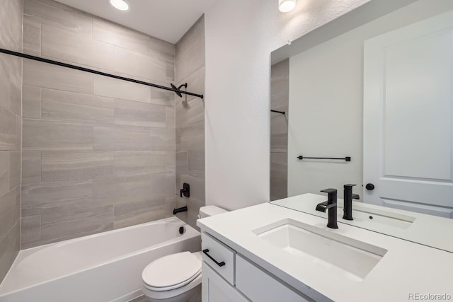 full bathroom featuring vanity, tiled shower / bath combo, and toilet