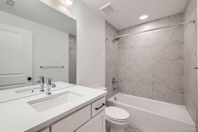 full bathroom with toilet, vanity, and tiled shower / bath