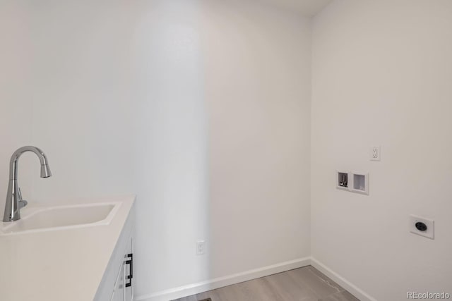 washroom with washer hookup, sink, wood-type flooring, and hookup for an electric dryer