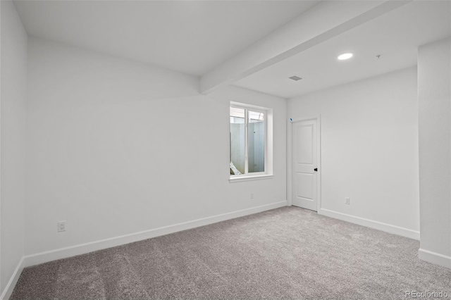 carpeted spare room featuring beamed ceiling