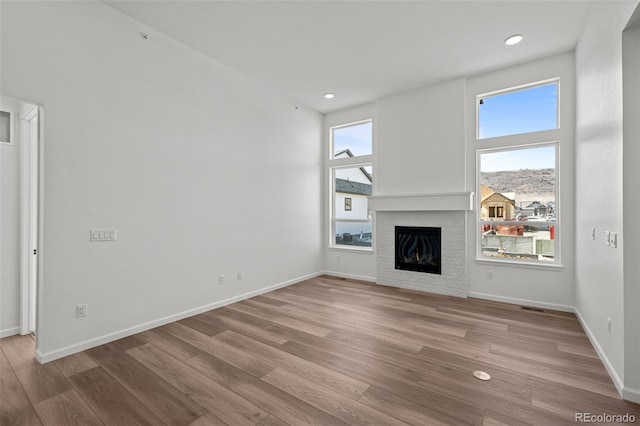 unfurnished living room featuring a wealth of natural light and light wood-type flooring