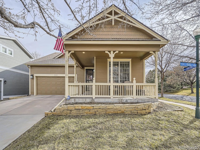 view of front of house featuring a porch, an attached garage, and concrete driveway